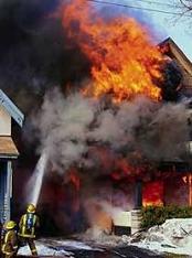 Fireman extinguishing large house fire